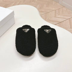 MULES ATTACHED TRIANGLE LOGO IN BLACK SHEARLING