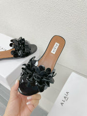 ALAIA FLAT MULE IN BLACK GLOSSY LAMBSKIN