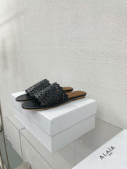 ALAIA VIENNE FLAT MULES IN BLACK LAMBSKIN