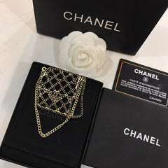 BAG SHAPED BROOCH IN GOLD METAL WITH BLACK CRYSTAL