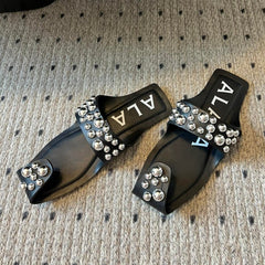 ALAIA FOLDED FLAT MULES WITH SPHERES ON BLACK CALFSKIN