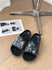 POOL GRAFFITI CROCS SLIDE SANDALS IN BLACK AND WHITE RUBBER