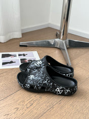 POOL GRAFFITI CROCS SLIDE SANDALS IN BLACK AND WHITE RUBBER