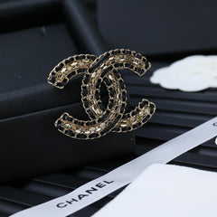 DOUBLE C BROOCH IN GOLD METAL WITH BLACK LEATHER THREADED CHAIN