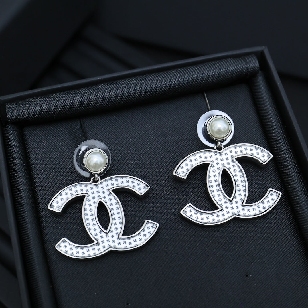 DOUBLE C EARRINGS IN SILVER METAL WITH BLACK SNOWFLAKE EMBOSSED ON WHITE ENAMEL