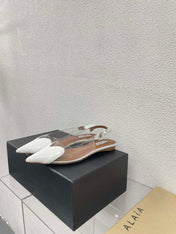 ALAIA LE COEUR FLAT SLINGBACKS IN WHITE PATENT LAMBSKIN