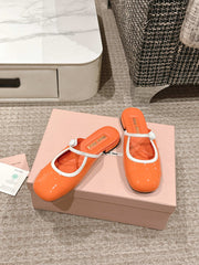FLAT MULE IN VIVID ORANGE PATENT CALFSKIN
