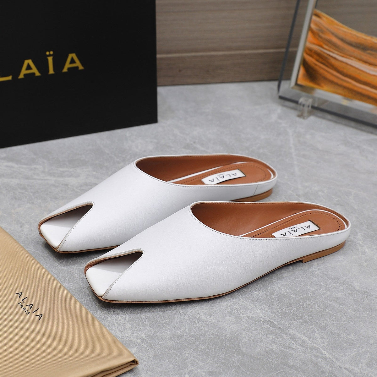 ALAIA FLAT MULE IN WHITE LAMBSKIN